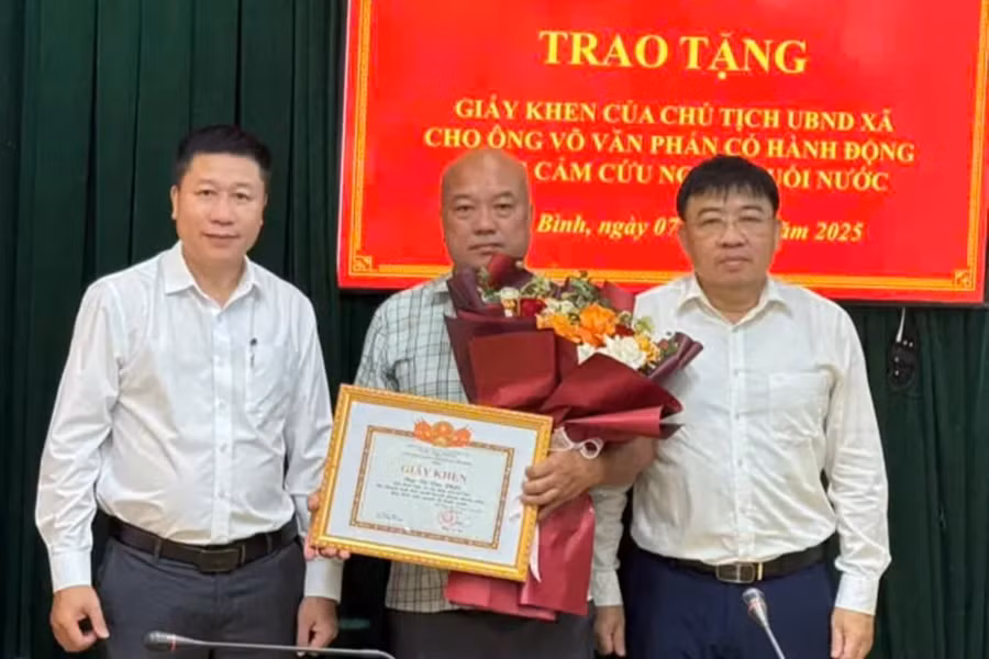 Ông Võ Văn Phấn nhận Giấy khen của Chủ tịch UBND xã Cẩm Bình vì hành động dũng cảm cứu người. (Ảnh:D.Q)