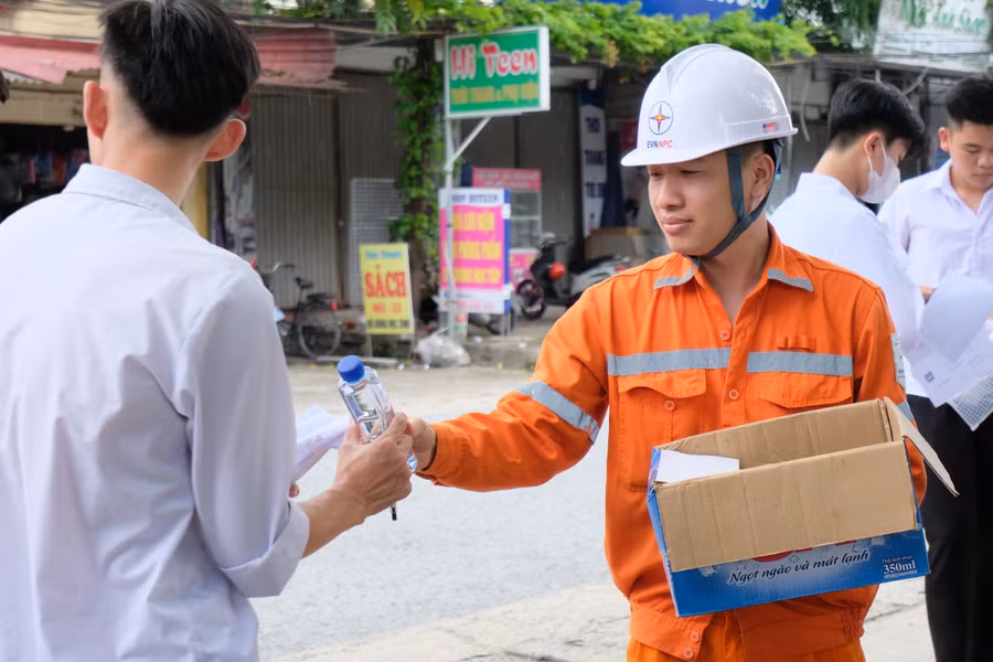 Tình nguyện viên "áo cam" phát nước miễn phí cho thí sinh tại điểm thi Trường THPT Triệu Quang Phục, Hưng Yên.