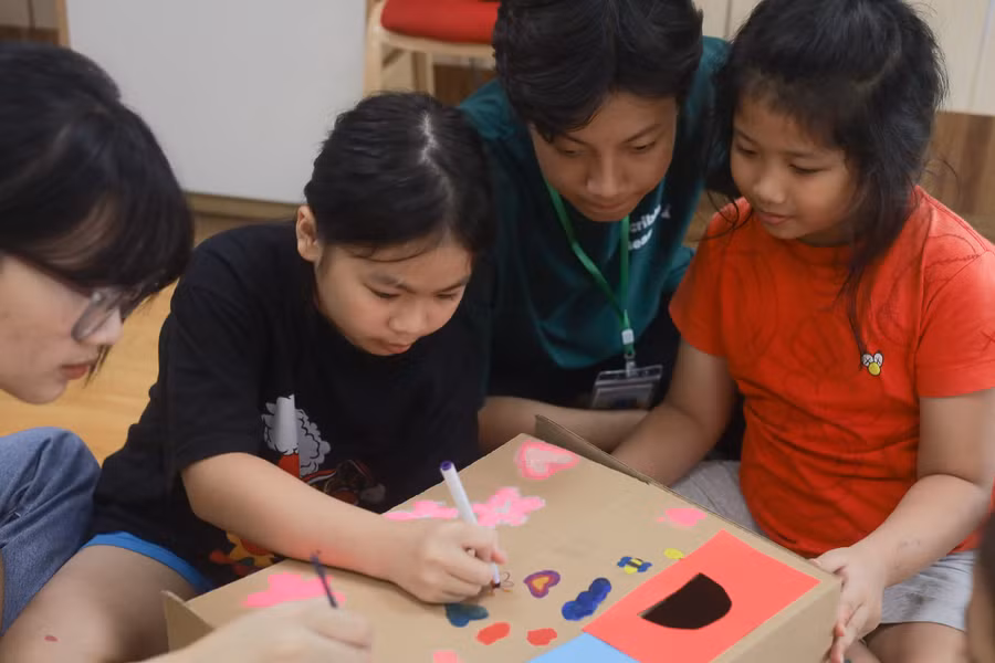 Tình nguyện viên hướng dẫn học sinh vẽ tranh khoa học. Tình nguyện viên hướng dẫn học sinh vẽ tranh khoa học.