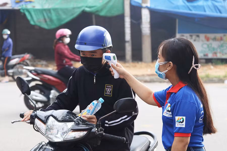 Học sinh được yêu cầu kiểm tra thân nhiệt trước khi vào trường thi.