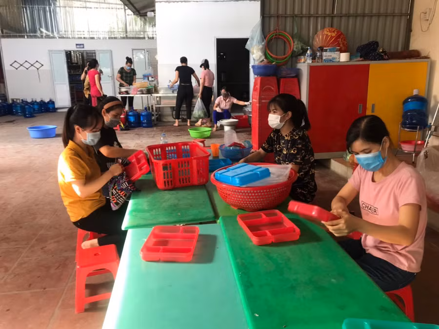 Giáo viên Trường Mầm non Đồng Tiến hỗ trợ nấu ăn tại khu trực chốt phòng dịch vào tháng 7/2021. Ảnh: NVCC.