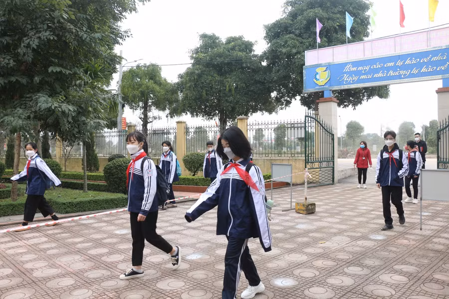 Học sinh chia thành hàng di chuyển vào trường.