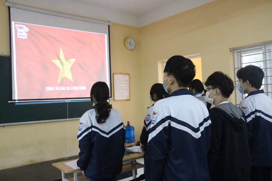 Học sinh làm lễ chào cờ trong lớp học.
