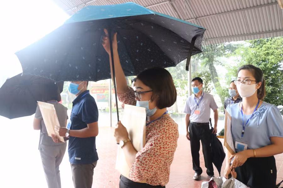 Cán bộ coi thi di chuyển về phòng thi.