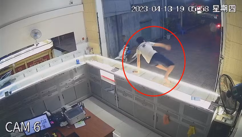Chủ tiệm vàng nhảy qua tủ kính để đuổi theo nhưng không đuổi kịp.
