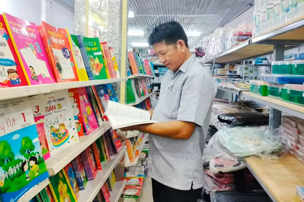 Một phụ huynh tìm mua sách giáo khoa cho con.