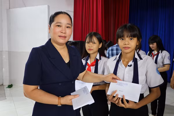 Bà Nguyễn Thu Tư - Giám đốc Sở Dân tộc và Tôn giáo tỉnh Cà Mau trao học bổng học sinh.