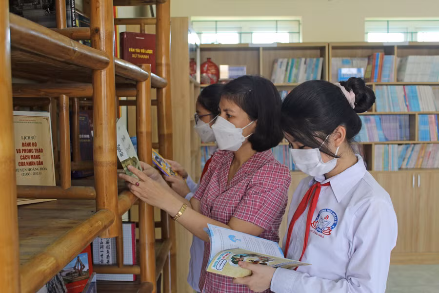 Cô Lê Thị Nhung cùng học sinh Trường THCS Nhữ Bá Sỹ (Hoằng Hóa, Thanh Hóa) đọc sách tại thư viện.