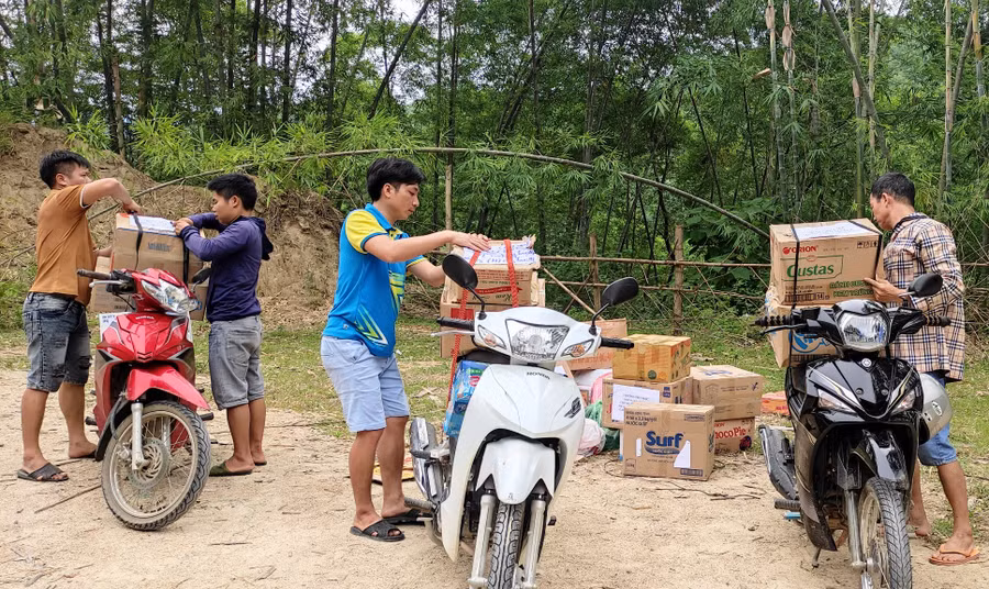 Các thầy giáo Trường Tiểu học Trung Lý 2 vận chuyển sách xuống đò. Ảnh: Thế Lượng. Các thầy giáo Trường Tiểu học Trung Lý 2 vận chuyển sách xuống đò. Ảnh: Thế Lượng.
