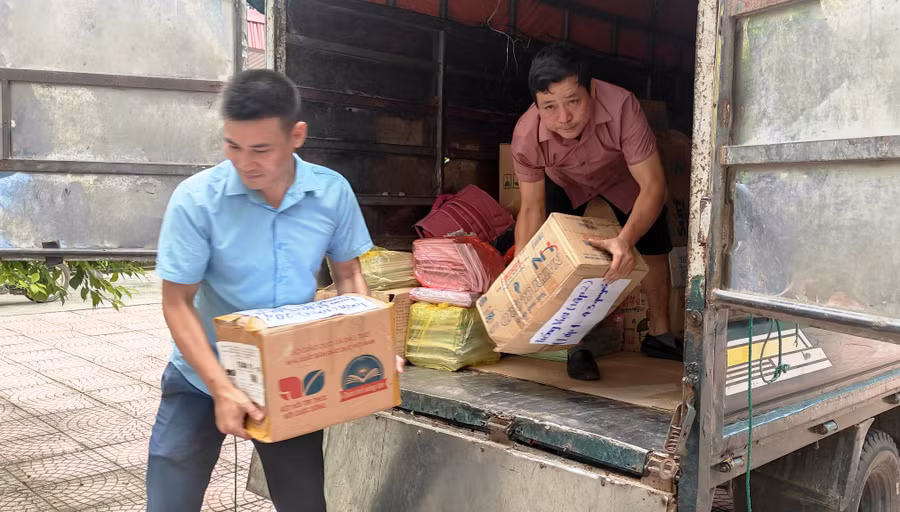 Bốc xếp SGK gửi tặng Trường Tiểu học Trung Sơn. Ảnh: TL. Bốc xếp SGK gửi tặng Trường Tiểu học Trung Sơn. Ảnh: TL.