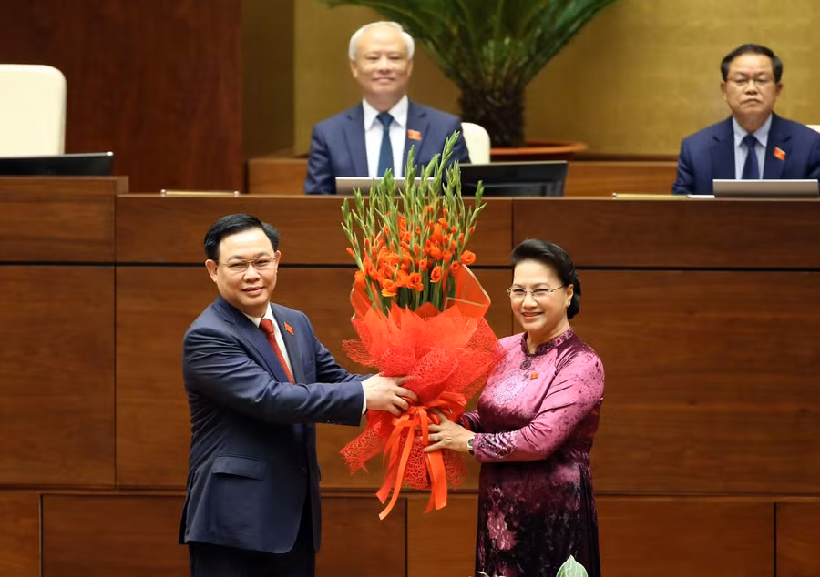 Tân Chủ tịch Quốc hội Vương Đình Huệ nhận bó hoa chúc mừng từ người tiền nhiệm. Ảnh: Quang Khánh
