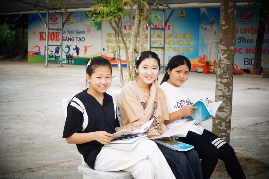 Thí sinh đến sớm tranh thủ xem lại bài học tại điểm thi Trường Phổ thông DTNT THPT số 2 tỉnh Nghệ An. Ảnh: Hồ Lài.