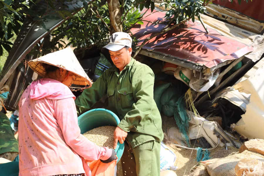 Người dân giúp gom lại lúa bị tràn ra cho chủ hàng. Ảnh: L. Phú
