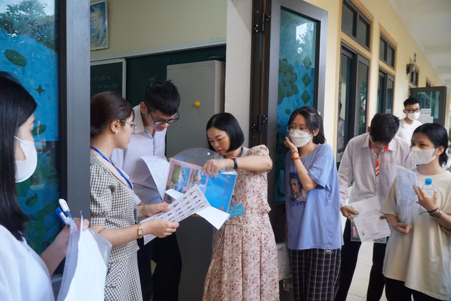 Giám thị kiểm tra vật dụng mang vào phòng thi của thí sinh. Ảnh: Hồ Lài.