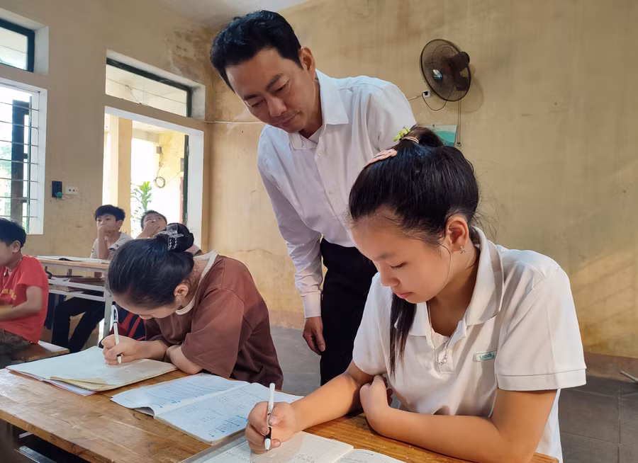 Thầy Lê Văn Sức và học trò của mình ở điểm trường Tân Sơn. Ảnh: TL.