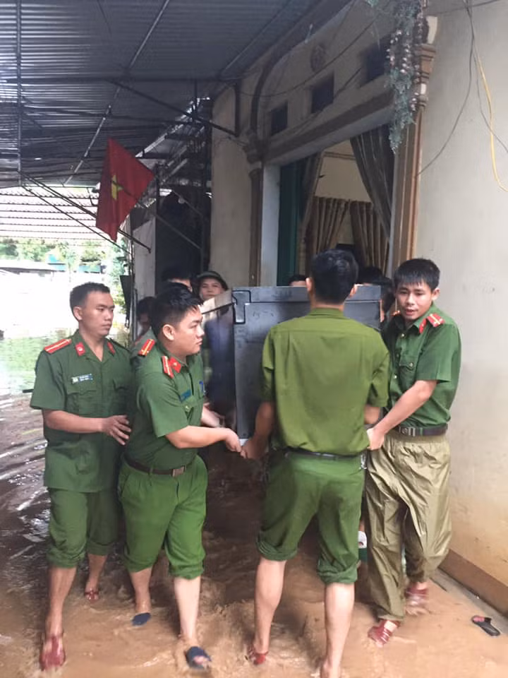 Lực lượng công an giúp sơ tán người dân và đồ đạc khi nhà bị ngập