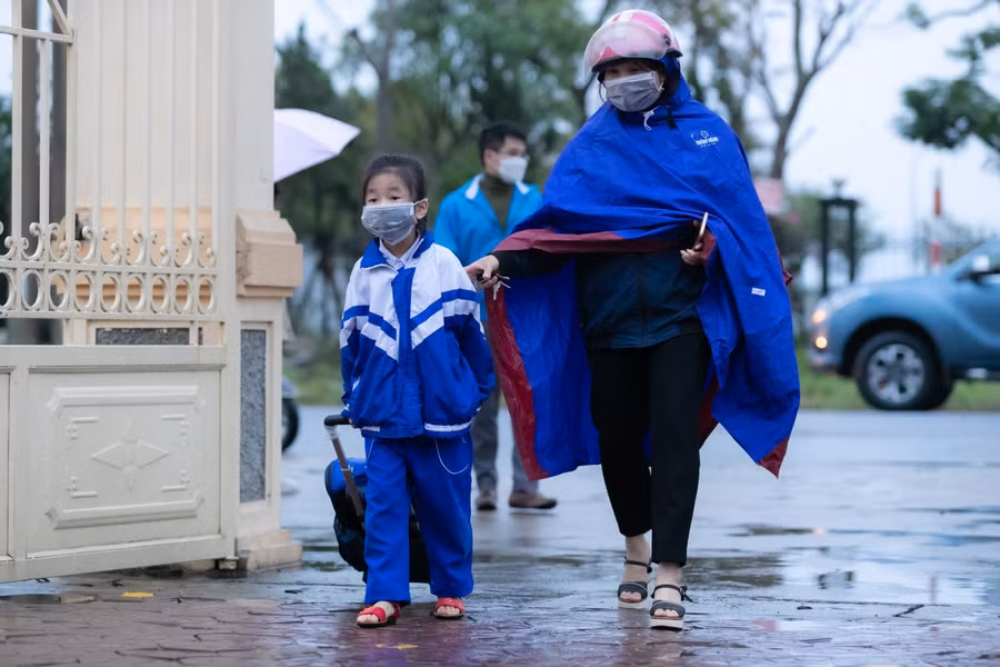 Buổi học đầu tiên thời tiết mưa rét nhưng các bạn học sinh tiểu học vẫn dậy sớm, được bố mẹ đưa đến trường đúng giờ.