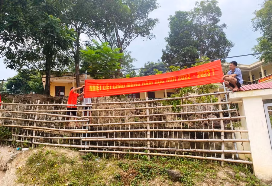 Các thầy giáo Trường Phổ thông Dân tộc bán trú THCS Mường Lý (Mường Lát, Thanh Hóa) treo băng zôn, khẩu hiệu chào mừng năm học mới.