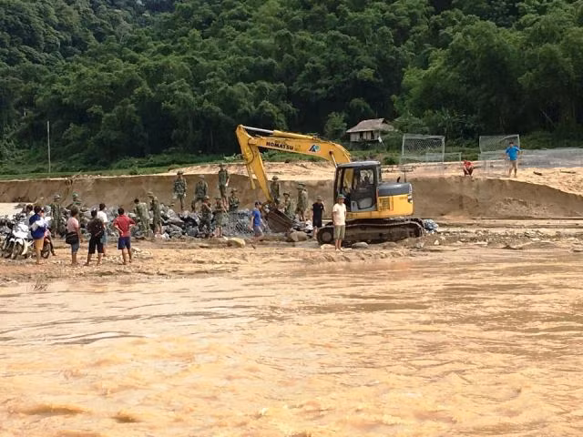 Dùng máy múc gạt cát, tạo mặt bằng đổ đá.