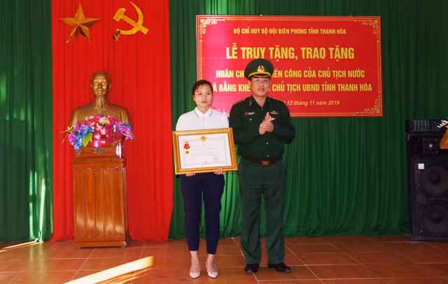 Chị Lương Thị Chon- vợ của liệt sĩ Vi Văn Nhất đón nhận Huân chương chiến công hạng Nhất do Chủ tịch nước truy tặng.