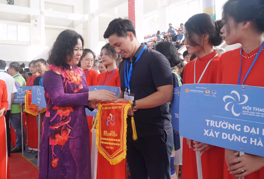 Thứ trưởng Bộ GD&ĐT Ngô Thị Minh trao cờ lưu niệm cho đại diện các đơn vị tham gia hội thao.