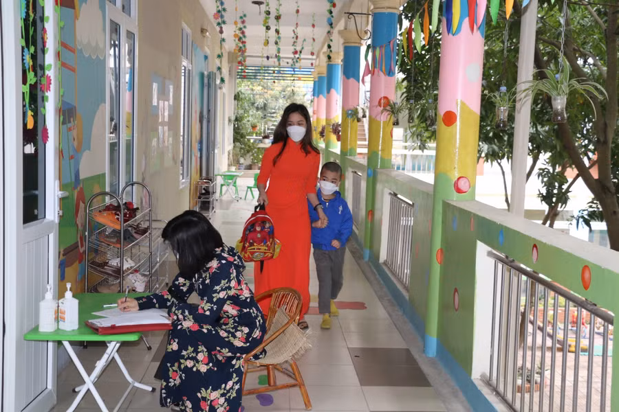 Sau một thời gian dài nghỉ học, nhiều học sinh không tránh khỏi bỡ ngỡ, các em được cô giáo dắt tay vào lớp học. Phụ huynh cũng ký cam kết phối hợp với nhà trường trong phòng dịch Covid-19 cho trẻ.
