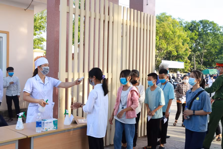 Đo thân nhiệt cho thí sinh trước khi vào điểm thi tại Trường THPT Kim Liên, Nam Đàn, Nghệ An