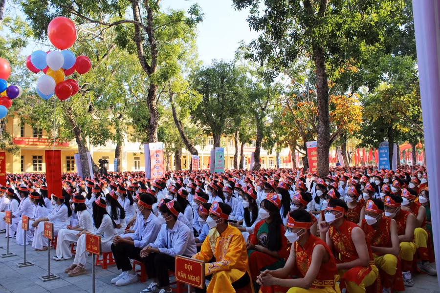 Học sinh các khối lớp ngồi ngay ngắn thành hàng, đồng thời đeo khẩu trang và sát khuẩn tay theo quy định phòng, chống dịch Covid-19.