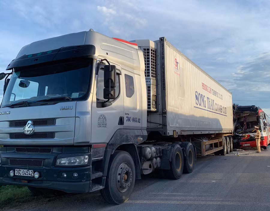 Chiếc xe Container đỗ bên đường cùng chiều với xe khách