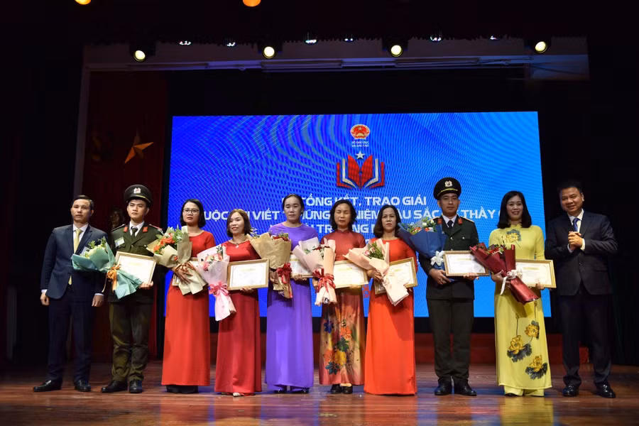 Ông Triệu Ngọc Lâm - Tổng biên tập Báo GD&amp;TĐ và ông Nguyễn Văn Cừ - Phó Chánh văn phòng Bộ GD&amp;ĐT lên trao giải Khuyến khích cho các tác giả.