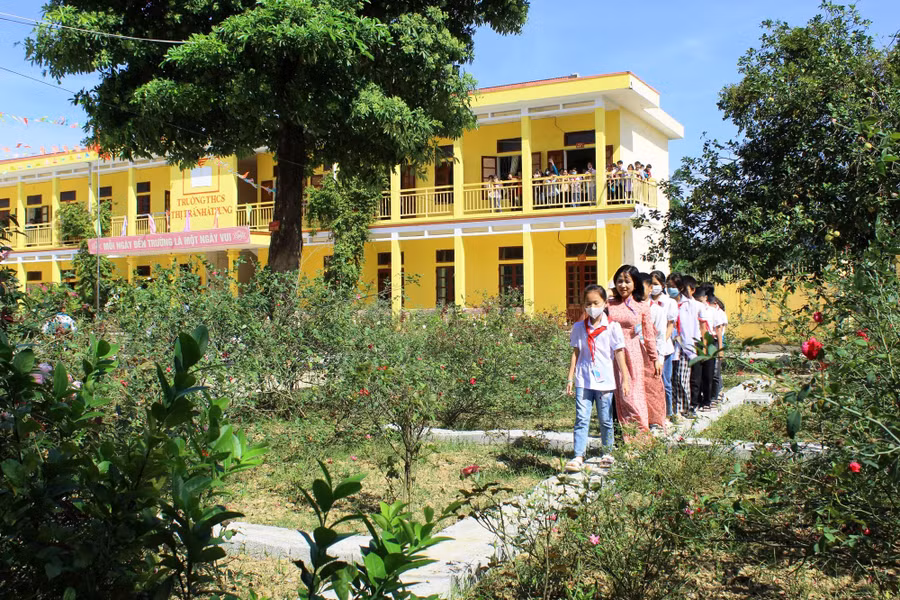Cô và trò Trường THCS thị trấn Hà Trung tham quan khu vườn hoa hồng của trường.