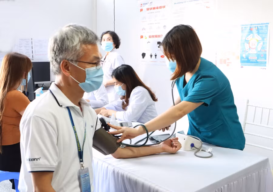 Công nhân khai báo y tế và khám sàng lọc trước khi tiêm