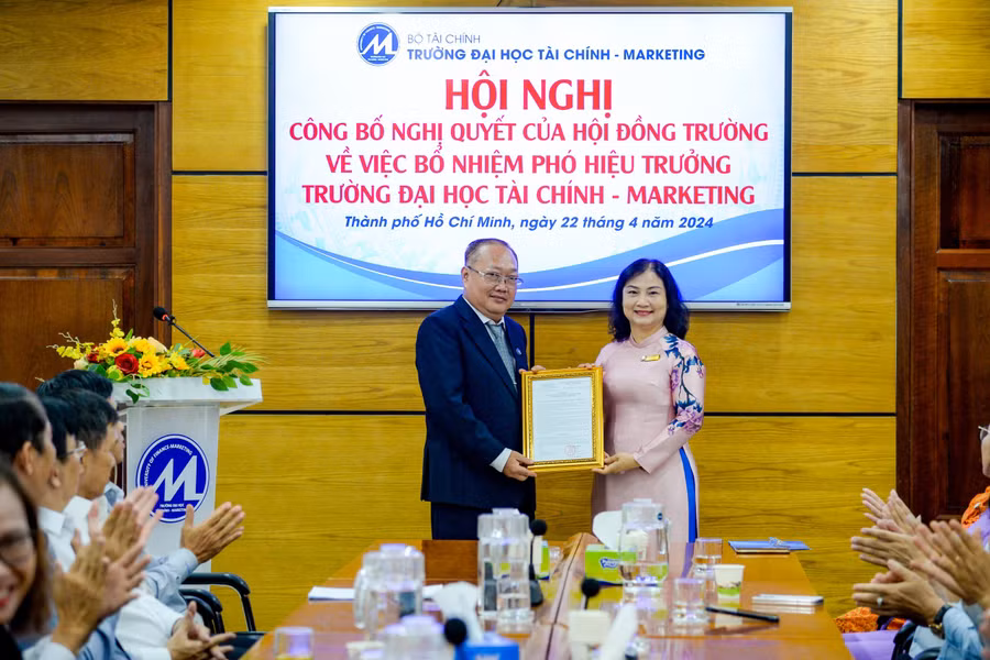 PGS.TS Hồ Thủy Tiên, Bí thư Đảng ủy, Chủ tịch Hội đồng trường (phải) trao quyết định bổ nhiệm TS Phạm Quốc Việt. Ảnh: UFM