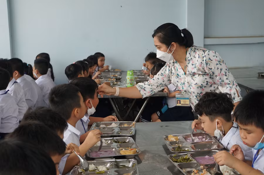 Giáo viên Trường Tiểu học Bông Sao, quận 8, TPHCM được tăng cường hỗ trợ trẻ trong bữa ăn bán trú. Ảnh: Mạnh Tùng