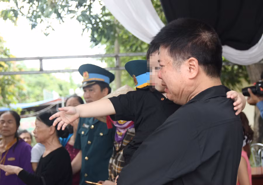 Cháu bé đưa tay ra với theo, chưa nhận thức được nỗi đau quá lớn
