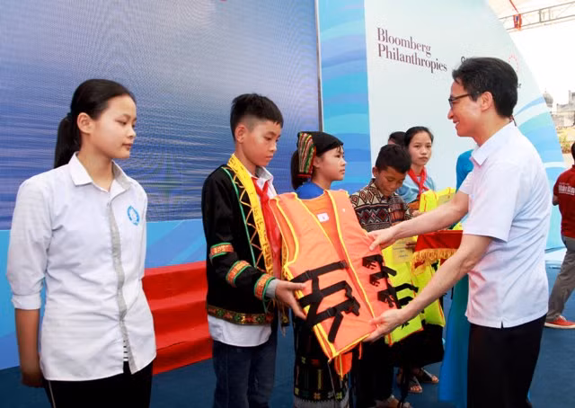 Phó Thủ tướng Chính phủ tặng áo phao cho trẻ em tại buổi lễ.