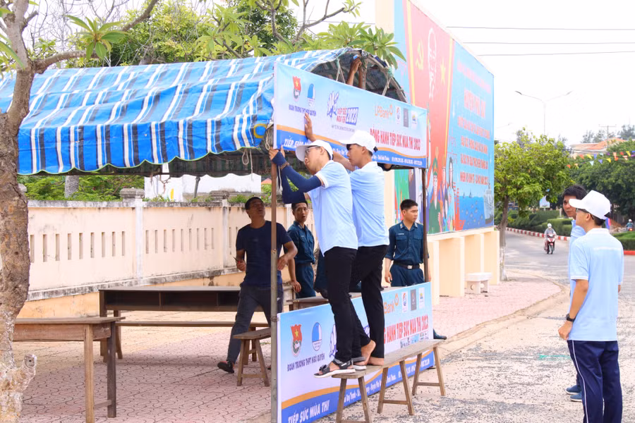 Lực lượng thanh niên, bộ đội, dân quân tự vệ chuẩn bị cho công tác tiếp sức mùa thi sáng 27/6. Ảnh: NTCC