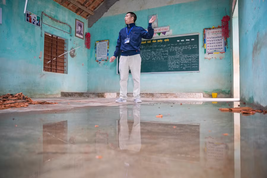 Bên trong dãy phòng học được niêm phong, treo biển cánh báo nguy hiểm là cảnh tượng ngổn ngang gỗ mục, ngói rơi vỡ, nước mưa dột vào thành vũng nước.