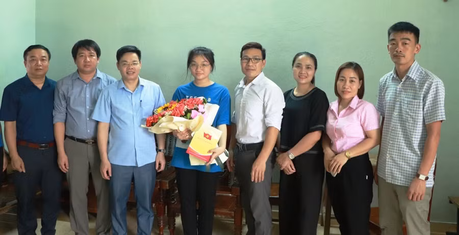 Ông Hà Văn Thủy (thứ 3 từ trái qua) - Phó Bí thư Thường trực Huyện ủy Quan Hóa cùng lãnh đạo Phòng GD&ĐT cùng Ban giám hiệu nhà trường tặng hoa cho nữ sinh Nguyễn Hà Phương tại gia đình em. Ảnh: NVCC.