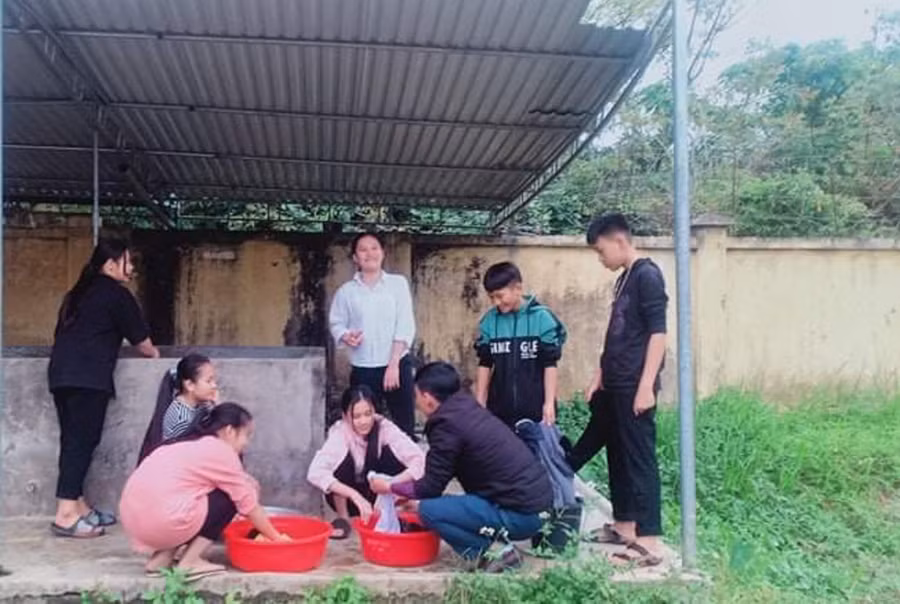 Giáo viên trường PTDT Nội trú THCS Tương Dương hướng dẫn học sinh cách giặt quần áo. Ảnh tư liệu