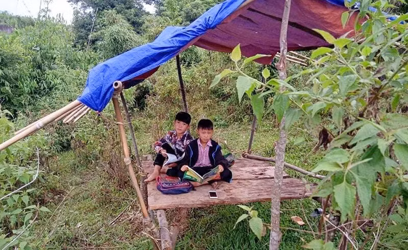 Em Xồng A Thành và Xồng A Dần (lớp 6A1 Trường Phổ thông Dân tộc nội trú THCS Quế Phong, Nghệ An), dựng lán học trực tuyến ở bản Mường Lống, xã Tri Lễ, Quế Phong dịp đầu năm học 2021-2022. Ảnh NVCC.