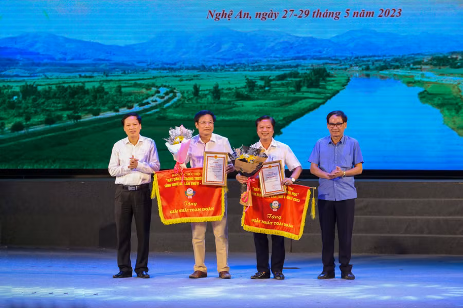 Ban tổ chức trao giải Nhất toàn đoàn Hội thi hát dân ca trong trường học tỉnh Nghệ An cho 2 đơn vị huyện Nam Đàn và Con Cuông. Ảnh: Hồ Lài.