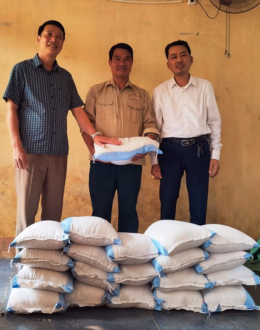 Thầy giáo và Trưởng bản Tân Sơn nhận số gạo từ thiện để cấp cho học sinh. Ảnh: TL.