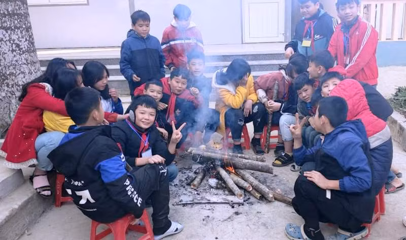 Học sinh Trường THCS Nam Tiến đốt lửa sưởi ấm ở góc sân trường.