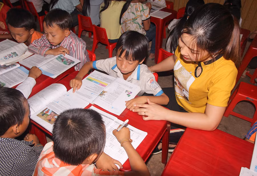 Học sinh ở bán trú tại Trường Tiểu học Huồi Tụ 2 (huyện Kỳ Sơn, Nghệ An) được thầy cô phụ đạo kiến thức buổi tối.