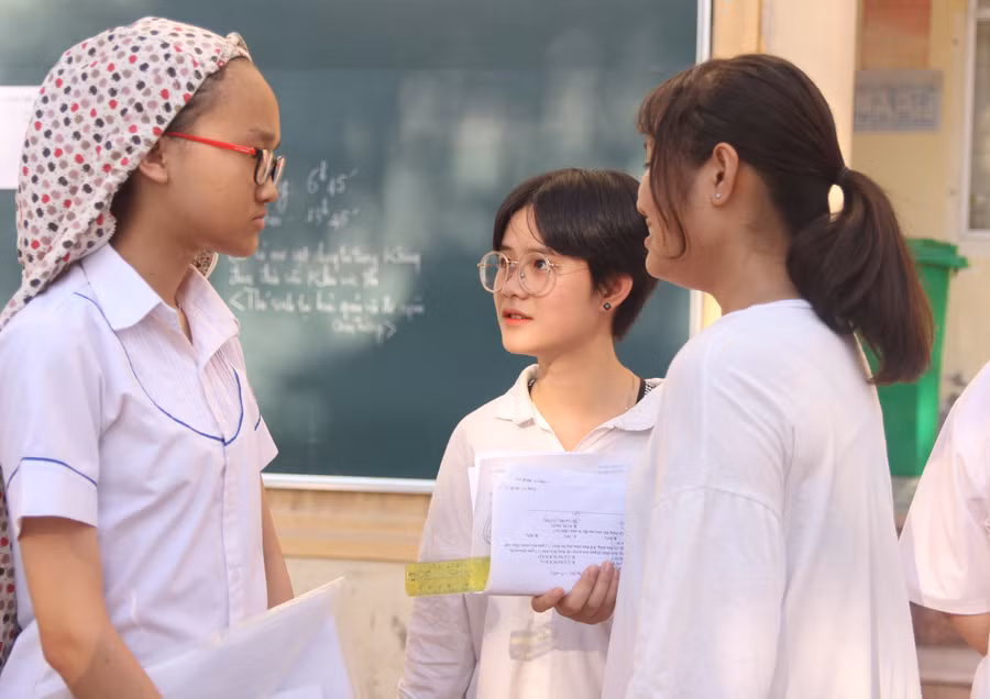 Thí sinh nán lại trường thi trao đổi về bài làm với bạn bè Thí sinh nán lại trường thi trao đổi về bài làm với bạn bè