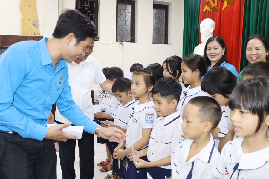 Ông Đặng Văn Hải - Chủ tịch Công đoàn giáo dục Nghệ An trao quà cho học sinh ở Làng trẻ em SOS Vinh. Ảnh: Hồ Lài.