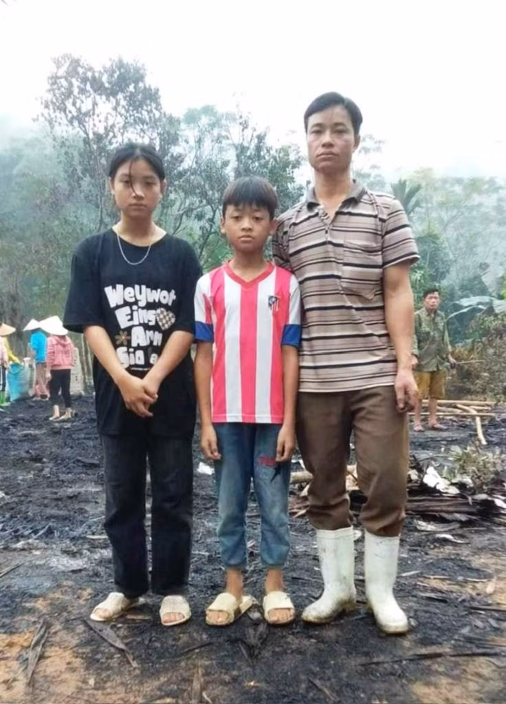 Hai chị em nữ sinh Lê Thị Mai Thuần, Lê Thuần Phong và bố đẻ trước ngôi nhà đã bị lửa thiêu rụi. Ảnh: Bạn đọc cung cấp