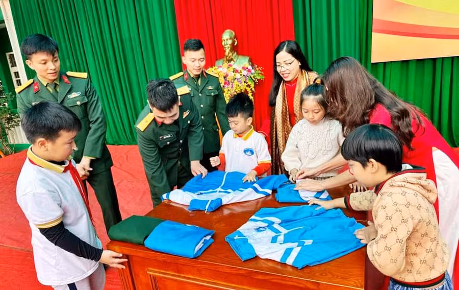 Học sinh hào hứng trải nghiệm cách gấp quần áo, chăn màn do các chú bộ đội hướng dẫn. Ảnh: NTCC Học sinh hào hứng trải nghiệm cách gấp quần áo, chăn màn do các chú bộ đội hướng dẫn. Ảnh: NTCC
