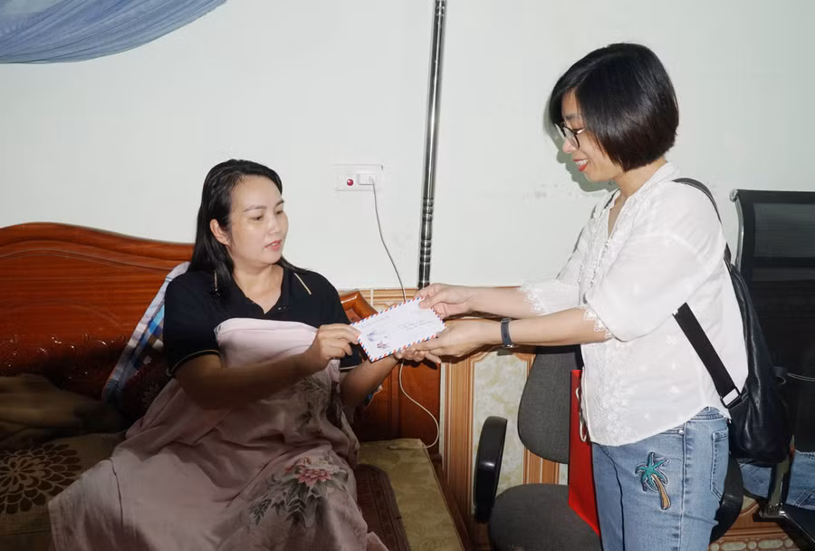 Đại diện Báo Giáo dục và Thời đại chuyển quà của Bộ GD&amp;ĐT đến cô giáo bị đất đá sạt lở vùi lấp cách đây 2 tuần. Ảnh: Hồ Lài.